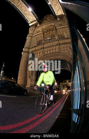 Ein Radfahrer in eine reflektierende Weste Fahrten über die Tower Bridge in London Night-Ride, London, Vereinigtes Königreich Stockfoto