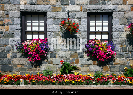 Typische Steinhäuser, meist einer Granitplatte, verziert mit vielen Blumen, Guernsey, Channel Islands, UK. Stockfoto