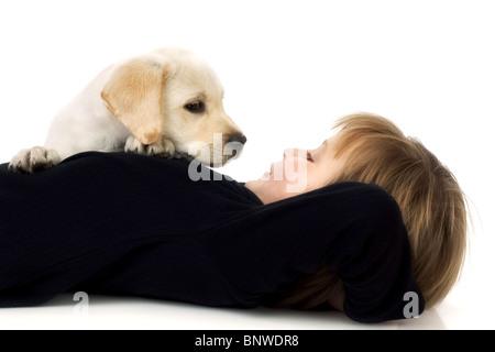 Kind mit Labrador-Retriever Welpen suchen Aufmerksamkeit Stockfoto