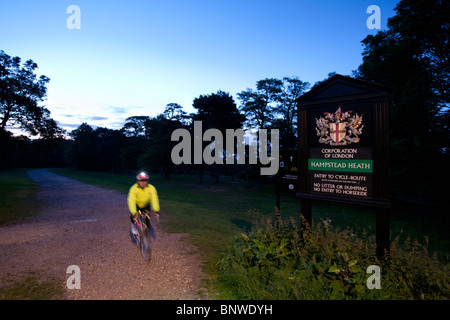 Ein Radfahrer in eine reflektierende Weste reitet auf einem Wanderweg auf der Nachtfahrt von London, London, Vereinigtes Königreich Stockfoto