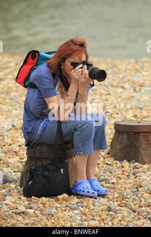 Eine Frau mit dem Fotografieren am Strand Eastbourne, East Sussex, England. Stockfoto