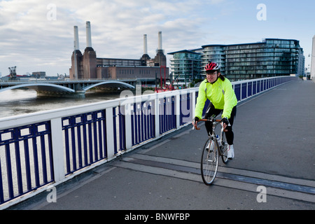 Ein Radfahrer in eine reflektierende Weste fährt über eine Brücke auf die Nachtfahrt London, London, Vereinigtes Königreich Stockfoto