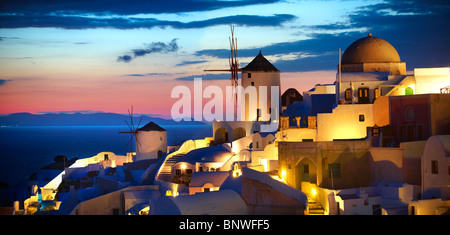 Oia (Ia) Santorini Windmühlen und Stadt bei Sonnenuntergang, Thira Island, griechische Kykladen-Inseln Stockfoto