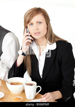 Besorgt Geschäftsfrau telefonieren beim Frühstück Stockfoto