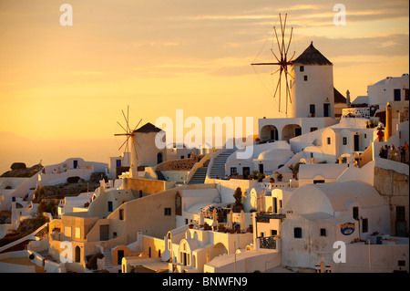 Oia (Ia) Santorini Windmühlen und Stadt bei Sonnenuntergang, Thira Island, griechische Kykladen-Inseln Stockfoto
