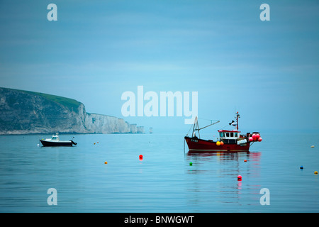 Angelboote/Fischerboote ankern in Swanage Bay Blick auf Old Harry Rocks in der Morgendämmerung, Dorset, Großbritannien Stockfoto