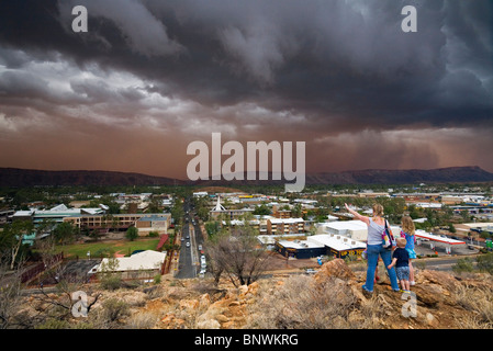 Eine junge Familie blickt auf Alice Springs, wie ein Sandsturm nähert sich die Outback-Stadt. Alice Springs, Northern Territory, AUST Stockfoto