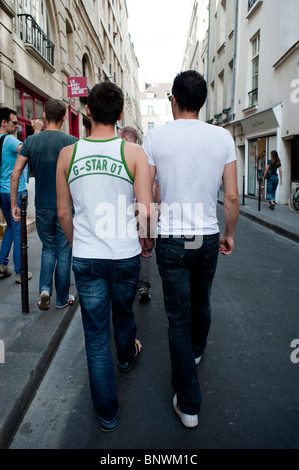 Junger Erwachsener, schwules männliches Paar auf einem Date, spazieren, die Straße hinunter im Marais-Viertel, Gay-Viertel von Paris hält Hände, Paris, Frankreich, Sommer, Vielfalt Paare, t-Shirts Stockfoto