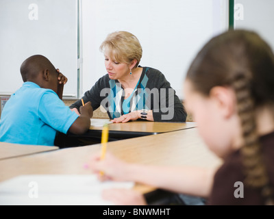 Lehrer helfen Schüler im Unterricht der Grundschule Stockfoto