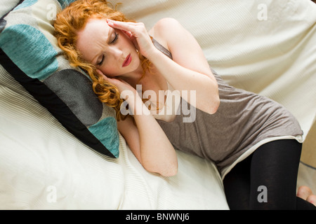 Frau liegend mit Kopfschmerzen Stockfoto