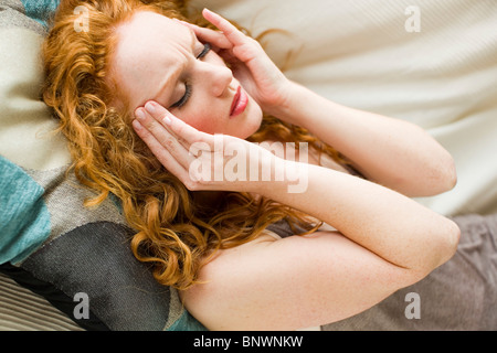 Frau liegend mit Kopfschmerzen Stockfoto