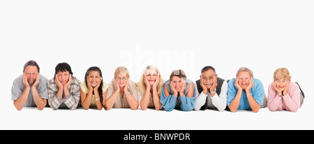 Eine Gruppe von Menschen, die auf dem Boden in einer Reihe Stockfoto