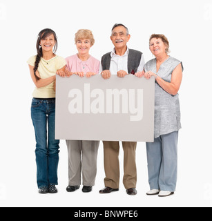 vier Personen halten ein leeres Plakat Stockfoto