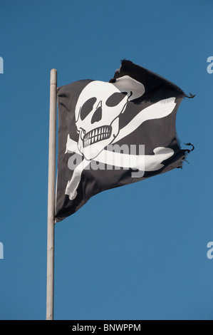 Totenkopf auf eine Flagge, die in einem strahlend blauen Himmel. Stockfoto