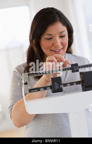 Frau stehend im Maßstab Stockfoto