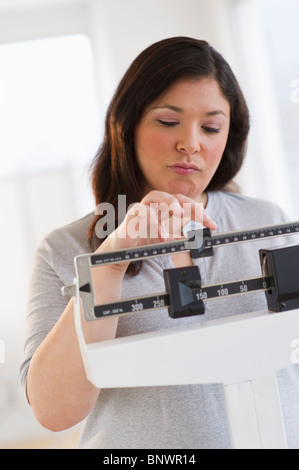 Enttäuscht Frau stand im Maßstab Stockfoto