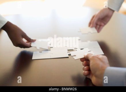 Hände, die Puzzle zusammenfügen Stockfoto