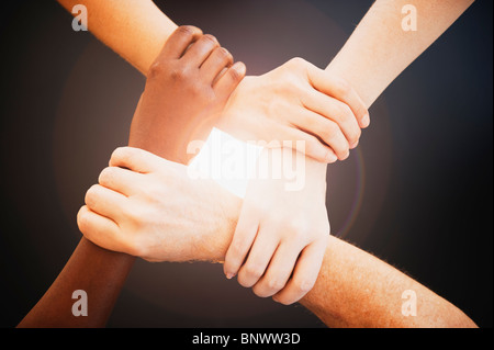 Vier Hände halten Handgelenke anderer Menschen Stockfoto