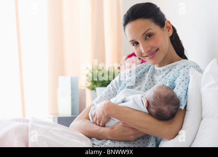 Mutter Holding neugeborenes Baby im Krankenhausbett Stockfoto