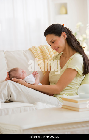 Mutter mit ihrem Baby auf Couch sitzen Stockfoto