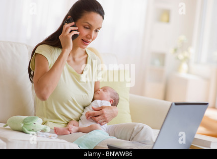 Mutter am Telefon sprechen, halten Sie ihr baby Stockfoto