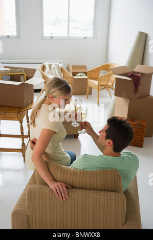 Glückliches Paar Toasten mit Champagner in ihrem neuen Zuhause Stockfoto