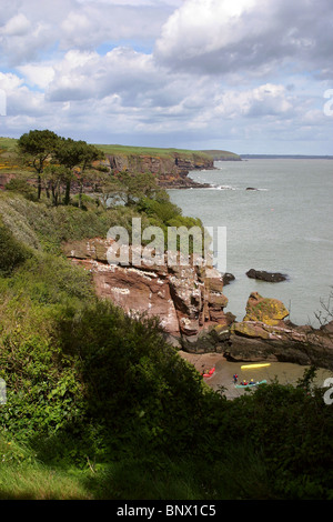 Irland, Waterford, Dunmore East, felsigen Küste Meer Kajakfahrer in geschützten Bucht Stockfoto