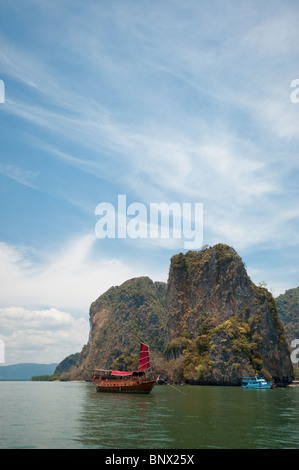 Müll und andere Ausflugsboote inmitten der ungewöhnlichen Kalkstein oder Karst, Inseln in der Bucht von Phang Nga, Thailand Stockfoto