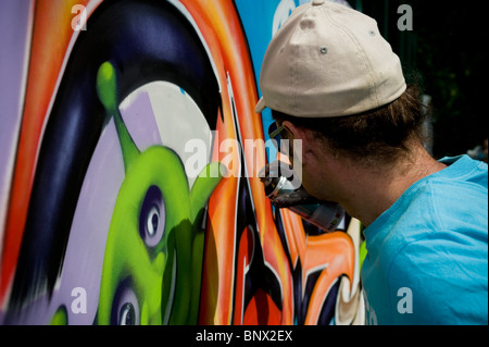 Graffiti-Künstler in der Brent respektieren Festival machen ein Wandbild mit Spraydosen, tragen von Schutzmasken Stockfoto