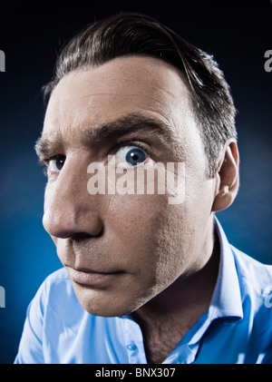 kaukasischen Mann beobachten misstrauisch Portraitstudio auf schwarzem Hintergrund isoliert Stockfoto