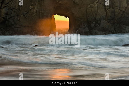 Die letzten Sonnenstrahlen die Einstellung Sonne Strahl durch die Pfeiffer Arch, Pfeiffer Beach, Big Sur, Kalifornien. Stockfoto