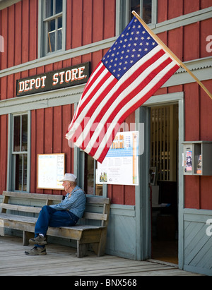 Besucher sitzen außerhalb des Bahn-Depots in Nevada City, eine Geisterstadt in Montana Stockfoto