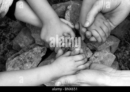 Erwachsenen- und Chilcren Hand in Hand um Stein Kreis Wunsch Wunsch Stockfoto