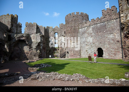 Frau liest Hinweisschild in der Ruine von Laugharne Castle Wales UK Stockfoto