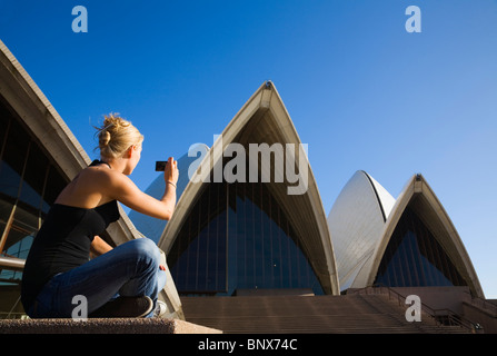 Eine Frau fotografiert das Opernhaus in Sydney, New South Wales, Australien. Stockfoto