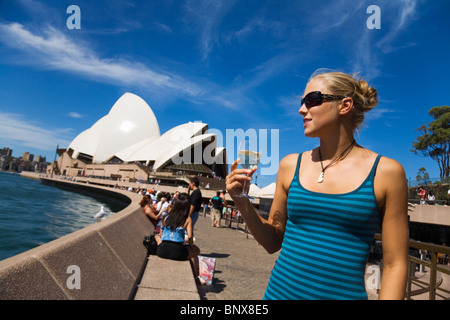 Eine Frau genießt einen Drink in der Opera Bar am Hafen von Sydney - Sydney, New South Wales, Australien. Stockfoto