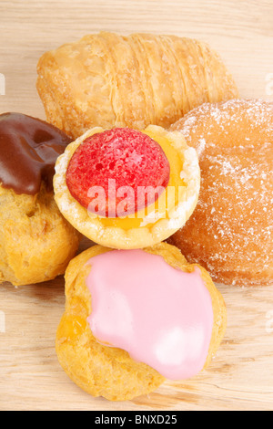 Verschiedene Tee Kuchen auf einem hölzernen Schneiden an Bord über einen grünen Hintergrund. Stockfoto