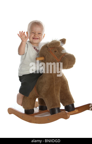 Kleinen lächelnden jungen auf Schaukelpferd Stockfoto