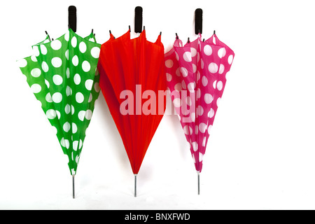 Drei bunte gefaltet Sonnenschirme auf einem weißen Hintergrund isoliert Stockfoto