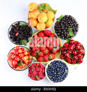 Verschiedene Beeren in Schalen, isoliert auf einem weißen Hintergrund. Stockfoto