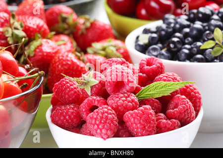 Verschiedene Beeren in Schalen. Schüssel mit verlockend Himbeeren in Front. Stockfoto