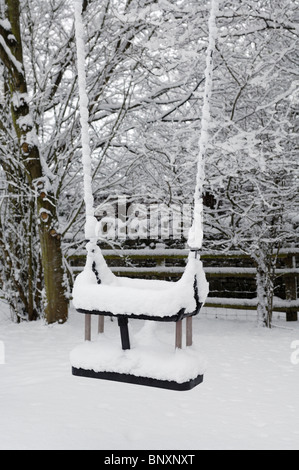 Ein Kinderspielplatz im Dorf unter einer Schneedecke. Wrington, Somerset, England. Stockfoto