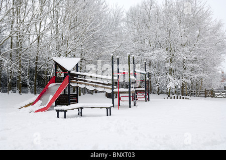 Ein Kinderspielplatz im Dorf unter einer Schneedecke. Wrington, Somerset, England. Stockfoto