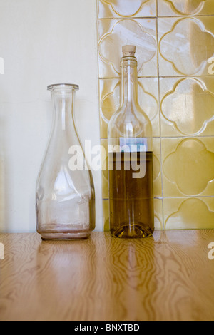 Leere Karaffe neben Flasche Wein Stockfoto