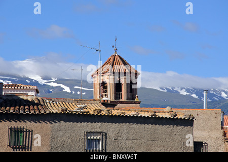 Stadthäuser und Kirchturm mit Schnee bedeckt Berge der Sierra Nevada nach hinten, Lacalahorra, Provinz Granada, Spanien. Stockfoto