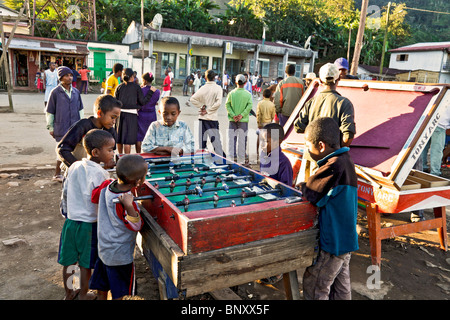 Jungs spielen Fußball / Fussball / Fußball in Ranomafana Dorf, Madagaskar, während andere ein Basketball Spiel beobachten. Stockfoto