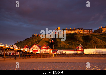 Dramatische goldenen Sonnenlicht shinning auf Saltburn Pier und viktorianischen Häusern am späten Abend. Stockfoto