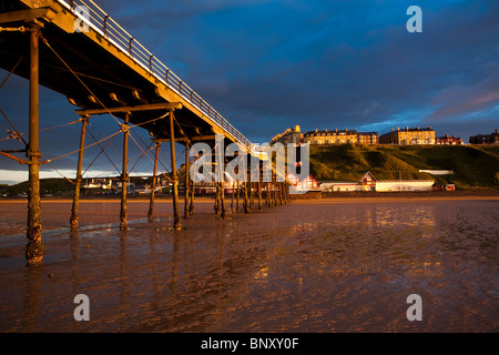 Dramatische goldenen Sonnenlicht shinning auf Saltburn Pier und viktorianischen Häusern am späten Abend Stockfoto