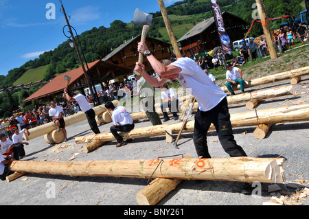 Holz hacken Wettbewerb konkurrieren Männer hacken Protokolle mit Achsen während ein Holz hacken Wettbewerb in Bernex, Frankreich Stockfoto