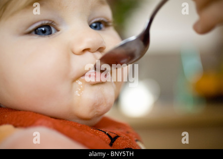 Kind mit einem Löffel gefüttert werden Stockfoto